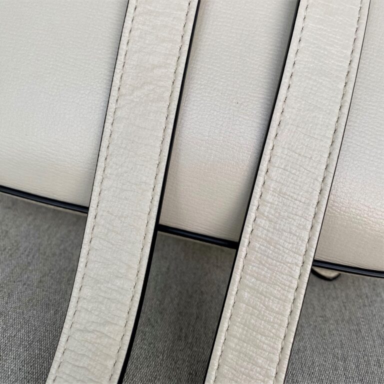 Image showing a ripple-like effect on the leather of a shoulder strap of a Gucci bag